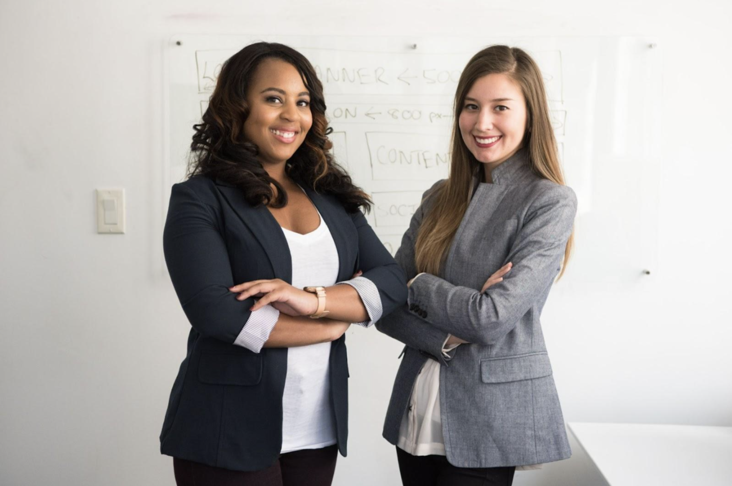 How to take cv photo at home example: two women wearing professional clothes smiling to the camera