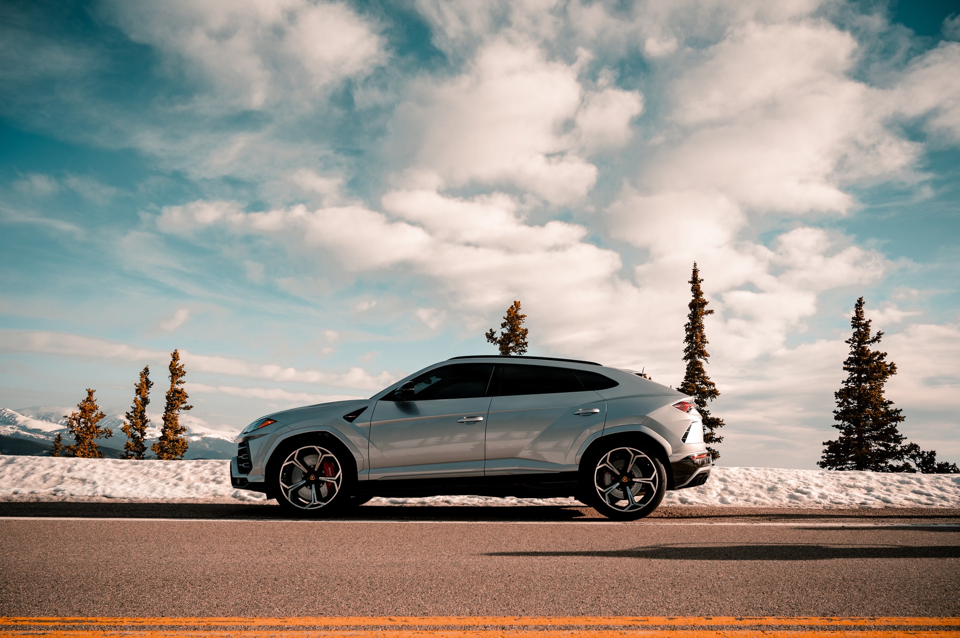 SUV car on a road with snowy mountains in the background