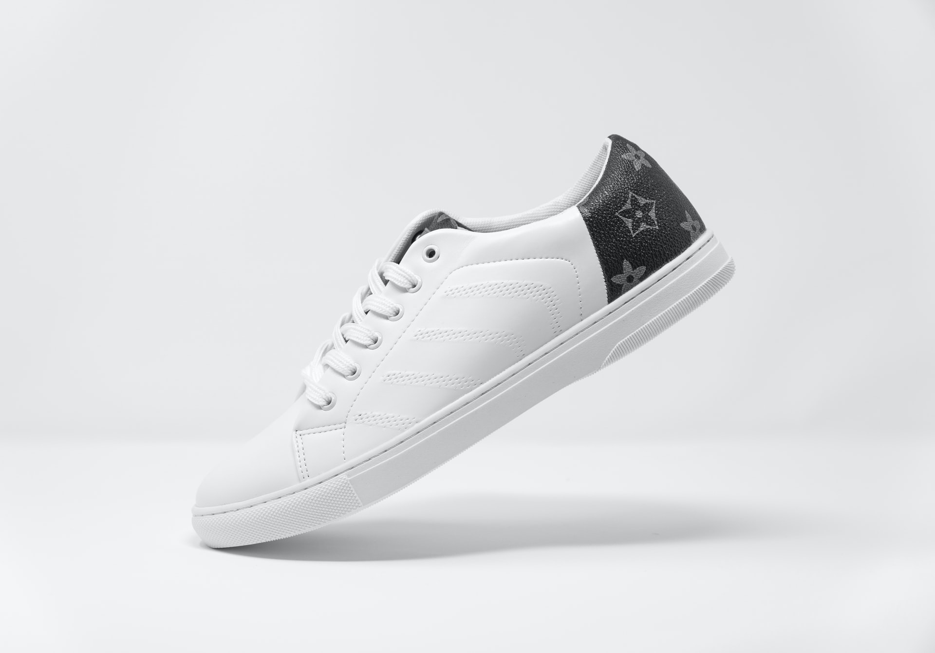 White sneaker on white background projecting a shadow