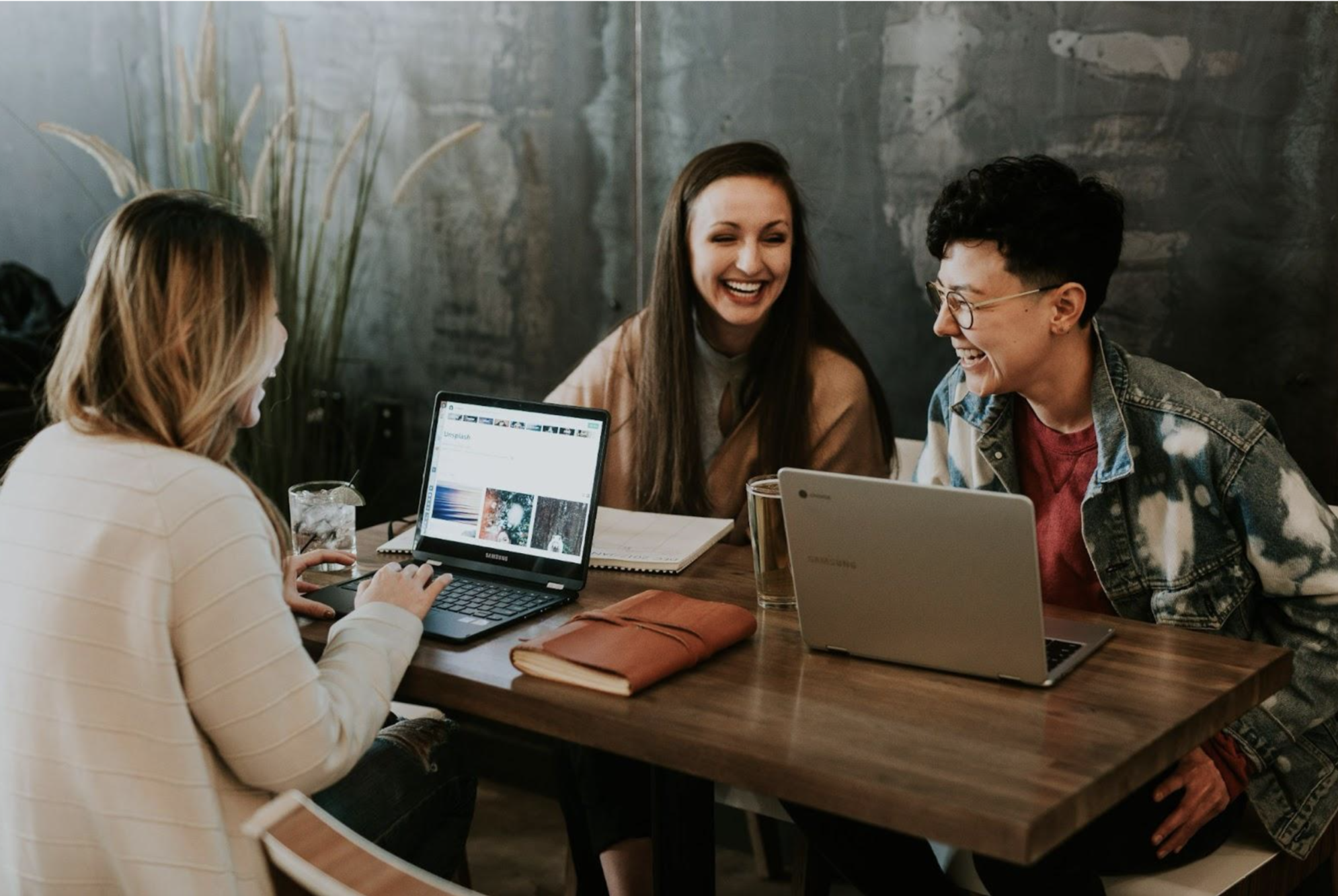 People smiling staring at their laptops' screens